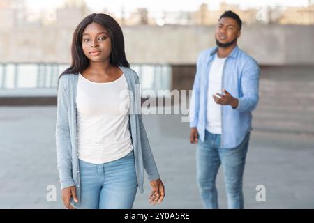 Triste nero donna lasciando il suo fidanzato denunziante dopo litigare Foto Stock