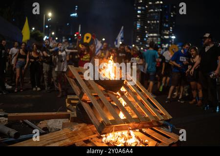 Tel Aviv, Israele. 1 settembre 2024. La famiglia, gli amici e i sostenitori degli ostaggi israeliani presi da Hamas a Gaza bruciano oggetti durante una protesta a Tel Aviv. Crediti: Ilia Yefimovich/dpa/Alamy Live News Foto Stock