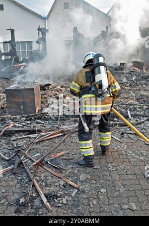 Vigile del fuoco con autorespiratore in azione Foto Stock