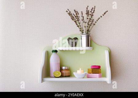 Elegante ripiano con articoli spa assortiti appesi a parete nel bagno di casa Foto Stock