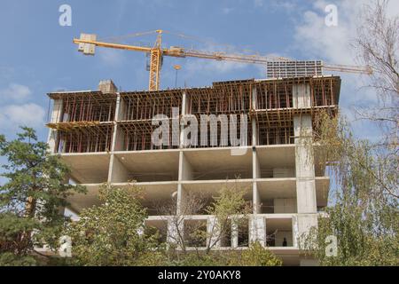 Un alto edificio in costruzione, con pareti in lastre di cemento e travi di legno per il supporto e la cassaforma Foto Stock
