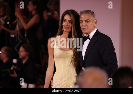 Venezia 1 settembre 2024 George e Brad. Uno con un classico abito con papillon nero, l'altro più casual con una giacca e una t-shirt nera. Al loro fianco i loro compagni di vita. Amal Clooney, moglie di George, che indossava un abito giallo pastello con corsetto, mentre la parte inferiore del vestito esplode dolcemente nella gonna con la coda sul retro. E soprattutto Ines de Ramon, la fidanzata di Brad, con un abito a spalla bianca drappeggiata, con una silhouette sirena. Crediti: Anfisa Polyushkevych/Alamy Live News Foto Stock