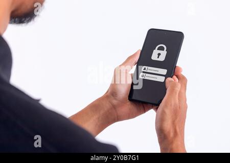 Uomo con uno smartphone per accedere al nome utente e alla password sullo schermo. Protezione online della privacy dei dati sull'applicazione per telefono cellulare. Foto Stock