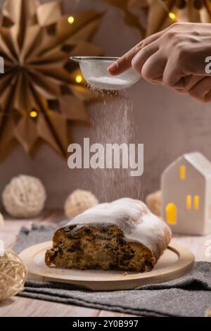 Torta tradizionale di Natale fatta in casa con zucchero in polvere cadente con noci di marzapane e pasticceria di frutta secca. L'atmosfera della stagione delle vacanze invernali. Delizioso tavolo con composizione casalinga spazio per le copie Foto Stock