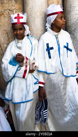 Le monache eritreo / pellegrini in piedi per la porta della chiesa del Santo Sepolcro nella città vecchia di Gerusalemme. Foto Stock