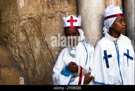 Le monache eritreo / pellegrini in piedi per la porta della chiesa del Santo Sepolcro nella città vecchia di Gerusalemme. Foto Stock