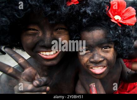 Ragazzi thailandesi con un corpo dipinto di nero e una parrucca afro durante un festival sulla strada Charoennakorn a Bangkok, Thailandia. Foto Stock