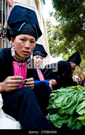 Black Yao Woman in un colorato mercato settimanale nella provincia meridionale dello Yunnan, vicino al confine del Vietnam, Cina. Foto Stock