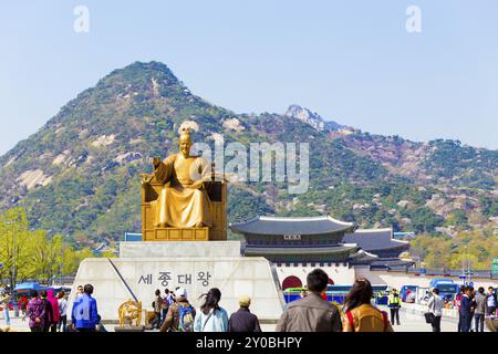 Seoul, Corea del Sud, 17 aprile 2015: Turisti che camminano intorno alla statua del re SAE Jong Dae Wang di fronte al Palazzo Gyeongbokgung e al monte Bugaksan a Do Foto Stock