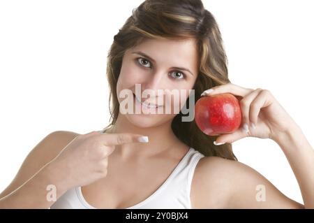 Donna sorridente e puntando ad una mela rossa ha sulla sua mano Foto Stock