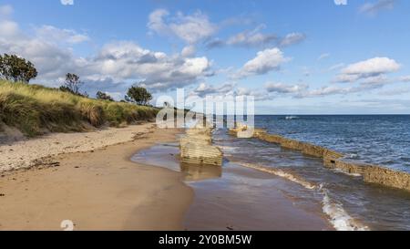 Costa del Mare del Nord ad Alnmouth nel Northumberland, Inghilterra, Regno Unito, con alcuni blocchi anticarro della seconda guerra mondiale sulla spiaggia Foto Stock