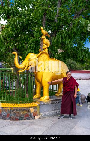 LHASA, TIBET CINA - 3 luglio 2022: Il monaco accanto all'ingresso del monastero di sera Foto Stock