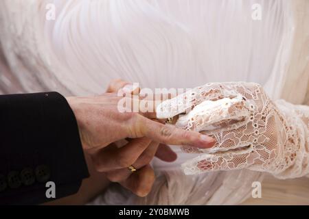 La sposa mette l'anello di nozze sul dito dello sposo Foto Stock