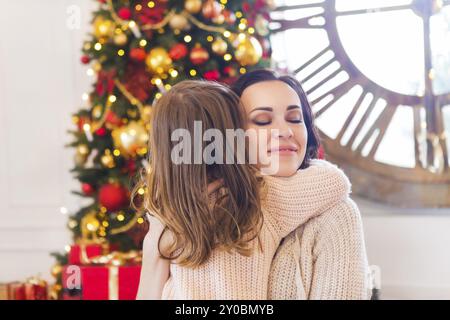 Allegro mamma e sua figlia carino con l'albero di Natale. La madre e il bambino divertirsi nei pressi di albero di Natale Foto Stock