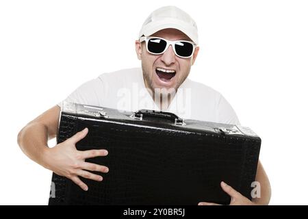 Uomo sorridente con gli occhiali da sole che reggono una valigia da viaggio grande isolata di colore bianco Foto Stock