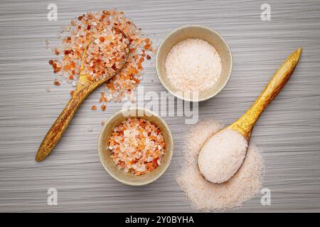 Una foto piatta di sale rosa grossolano e fine dell'Himalaya in ciotole e cucchiai Foto Stock