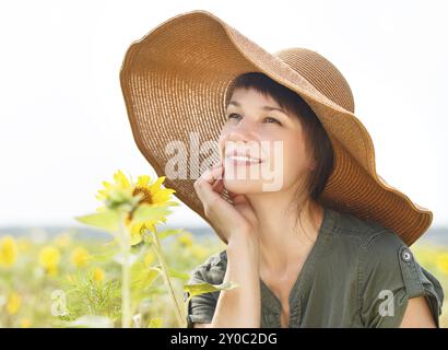 Ritratto di una giovane donna sorridente con girasole nelle giornate di sole Foto Stock