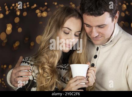 Ritratto di una felice coppia giovane su sfocata sullo sfondo delle luci Foto Stock