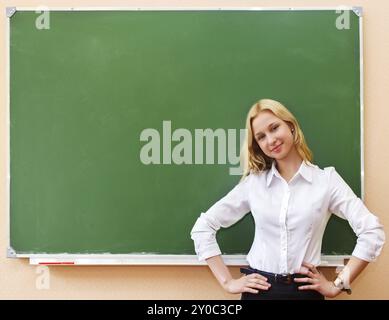 Ragazza dello studente in piedi vicino a lavagna in classe Foto Stock