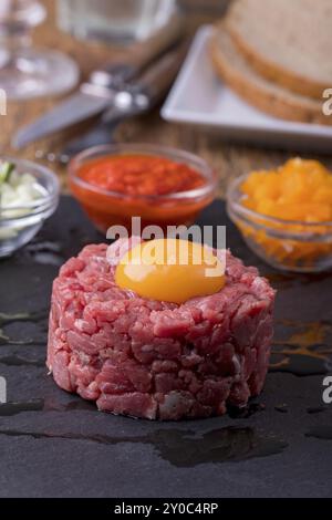 Tartare di bistecca con uovo su ardesia Foto Stock