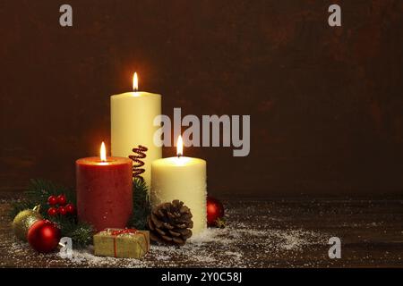 White and red candles with christmas decorations on rustic wooden background and snow, copy space. Greetings card template Stock Photo