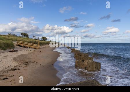 Costa del Mare del Nord ad Alnmouth nel Northumberland, Inghilterra, Regno Unito, con alcuni blocchi anticarro della seconda guerra mondiale sulla spiaggia Foto Stock