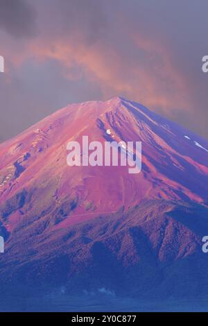 Lo splendido cielo rosa illumina la cima del cono vulcanico rosso del Monte Fuji in una vista dettagliata del teleobiettivo in una mattina estiva a Kawaguchiko, 5 laghi, Giappone. Foto Stock