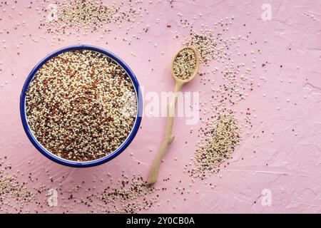 Mix di quinoa. Semi di quinoa bianchi, rossi e neri in una ciotola, con un cucchiaio di legno, foto in alto con spazio di copia, fotografia gastronomica Foto Stock