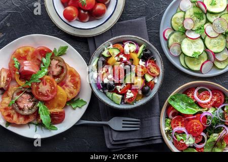 Insalate vegetariane fresche, piatto piatto alto di un assortimento. Varietà di piatti e ciotole con verdure verdi. Cibo sano, ottimo Foto Stock