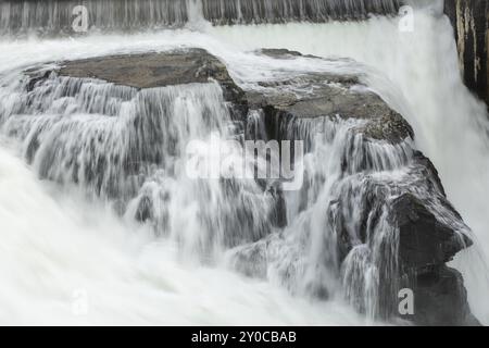 L'acqua del fiume Spokane scorre rapidamente su grandi rocce presso la Post Falls Dam di Post Falls, Idaho Foto Stock