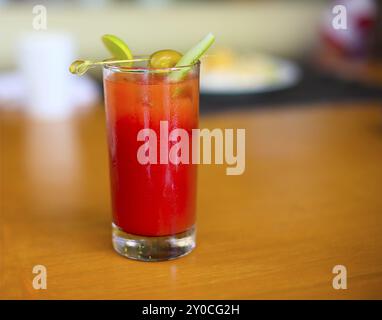 Bloody Mary cocktail in un affollato bar top guarnito con cipolle, olio d'oliva e selery Foto Stock