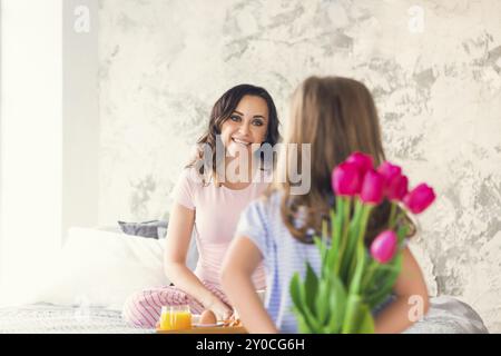 Giovane donna e bambina con tulipani. La festa della mamma concept Foto Stock