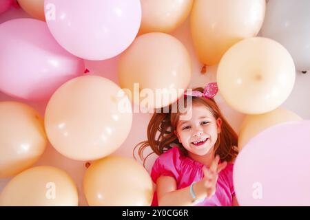 Ritratto della cute bambina in stile retrò su sfondo palloncini. Concetto di compleanno Foto Stock