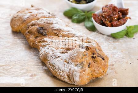 Freschi di forno Ciabatta con pomodori secchi, basilico e olive Foto Stock