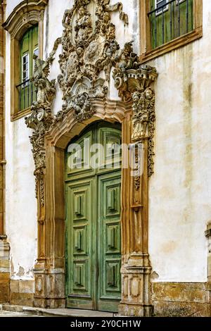 Facciata della chiesa di Sao Francisco de Paula a Ouro Preto, Minas Gerais con le sue finestre, grande porta in legno, arco in pietra e sculture barocche Foto Stock