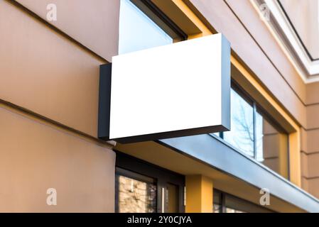 Disegno bianco del mockup del cartello Cafe White su Una parete gialla Foto Stock