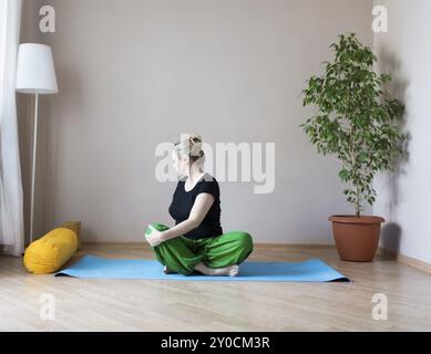 Persone di mezza età o donna matura fare yoga in ambienti interni Foto Stock
