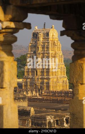 Il tempio Virupaksha, tra le rovine di un'antica civiltà, incorniciato da colonne di pietra a Hampi, Karnataka, India, Asia Foto Stock