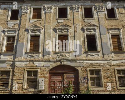 Una facciata fatiscente con finestre bloccate e dettagli architettonici, bratislava, slovacchia Foto Stock