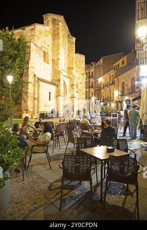 Ristoranti sulla Plaza Mayor di notte, dietro la chiesa romanica Iglesia de San Juan de Puerta Nueva o San Juan Bautista, centro storico di Zam Foto Stock