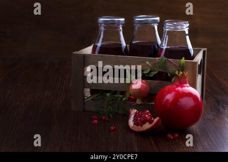 Succo di melograno e frutta su sfondo di legno scuro, messa a fuoco selettiva Foto Stock