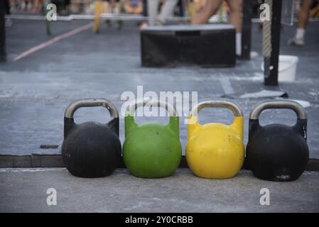 Vista frontale di tre coloratissimi kettlebell mostrati con area esercizi dietro. Palestra con attrezzature fitness per allenamenti e allenamenti, Barcellona, Foto Stock