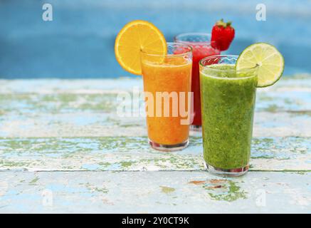 Assortimento di frutta e verdura frullati in vetro bianco su sfondo di legno. Fresco frullato di organico. Superfoods e salute o detox la dieta con alimenti Foto Stock