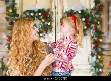 Felice madre e il suo bambino figlia insieme dalle decorazioni di Natale Foto Stock