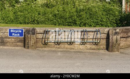 Una bicicletta rack con un segno, visto in Llanddulas, Conwy, Wales, Regno Unito Foto Stock