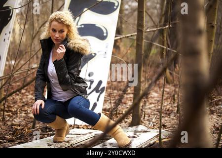 Giovane donna bionda con lunghi capelli ricci in un ambiente autunnale all'aperto Foto Stock