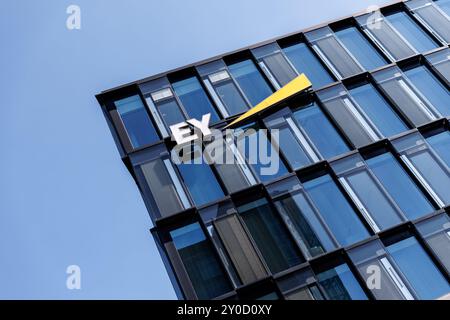 Monaco, Germania. 29 agosto 2024. Il logo della società di revisione Ernst & Young (EY) è visibile sulla facciata di fronte alla sede centrale della società a Monaco il 29 agosto 2024. EY è una rete globale di società giuridicamente autonome e indipendenti nei settori della revisione contabile, della consulenza fiscale, della consulenza sulle transazioni, della consulenza sui rischi, della consulenza finanziaria, nonché della consulenza aziendale e gestionale e della consulenza legale tradizionale. Crediti: Matthias Balk/dpa/Alamy Live News Foto Stock