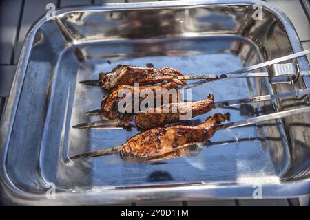 Grigliare gli spiedini con pollo marinato in un recipiente di metallo Foto Stock