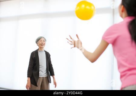 Una donna anziana e una badante che si divertono a giocare con una palla Foto Stock