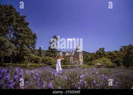Una donna sta in piedi in un campo di fiori viola Foto Stock